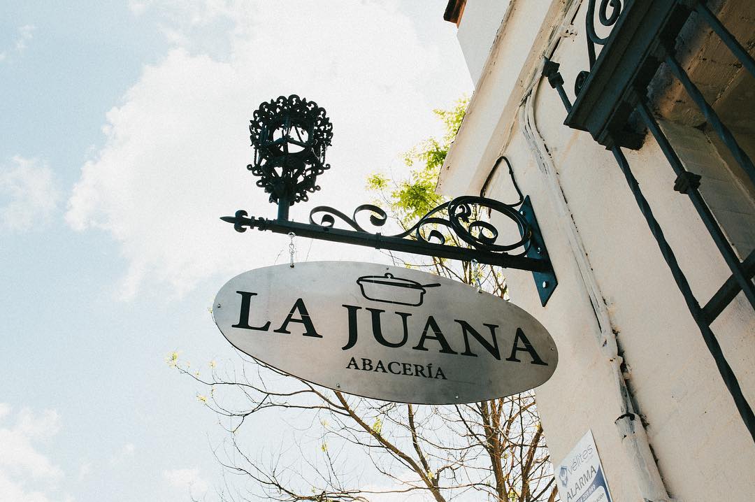 cartel-abaceria-la-juana-sevilla Cartel de La Juana, abacería en Sevilla, que muestra la fachada tradicional del establecimiento